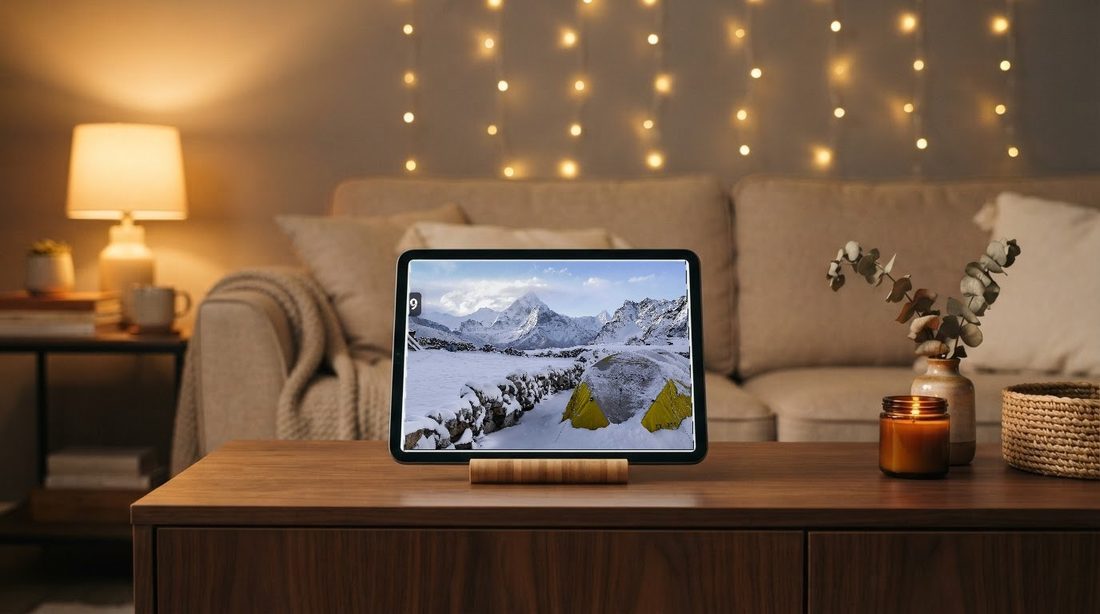 An Android tablet on a sideboard in the evening, showing a photo with a clock and weather overlay